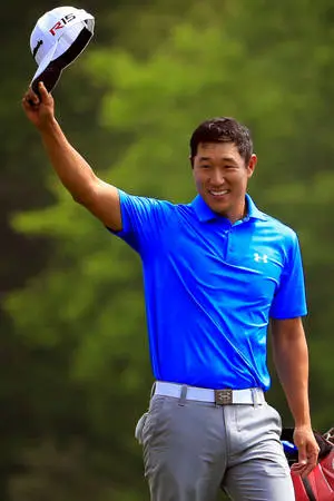 Professional golfer James Hahn smiling and holding his golf cap.